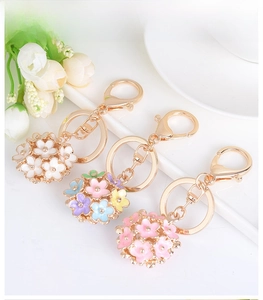 Close-up of enamel daisy flower keychains in white, pink, and colorful macaron shades