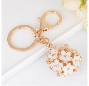 Detailed macro view of an elegant white daisy flower ball keychain with gold accents