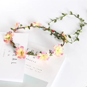 Pastel pink and yellow floral wreath headband with green leaves on minimalist magazine