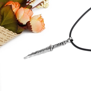 Collana con ciondolo a pugnale in argento e cordino in pelle nera su sfondo bianco