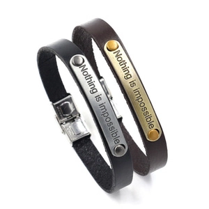 Detail of woven leather bracelets with engraved Nothing is impossible metal plates