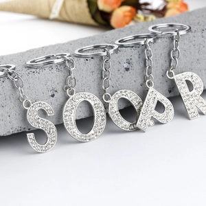 Detailed shot of silver-plated alphabet keychains with sparkling rhinestones on stones