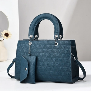 Detail of teal tote bag with triangle embossed texture and detachable mini pouch