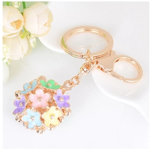 Detailed macro view of a floral keychain with colorful enamel flowers and a golden clasp