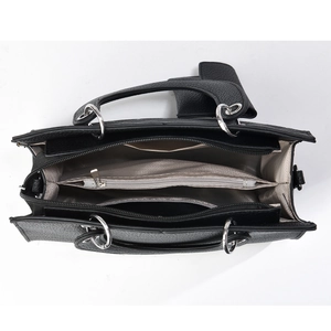 Top view detail of the black handbag interior with three compartments and silver hardware