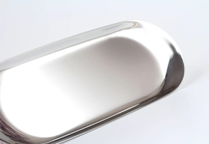 Macro view of polished silver stainless steel oval tray showing reflective mirror finish