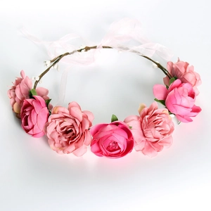 Bohemian floral crown with pink faux flowers and green leaves on white background