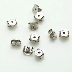 Multiple 925 sterling silver earring backs scattered on white reflective surface