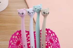Detail of four colorful cute cat-shaped pens in a pink desktop organizer stand