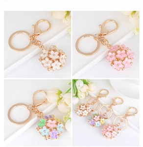 Detailed display of enamel flower high heel shoe keychains in white and pink color options