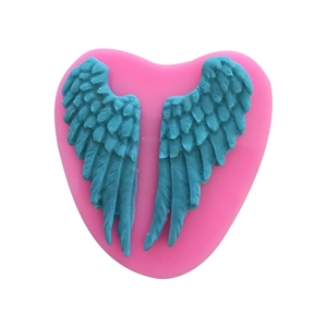 Pink heart-shaped silicone cake mold with detailed angel wing texture for baking
