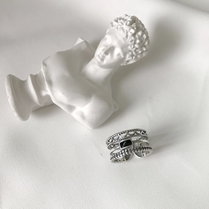 Detail view of vintage 925 silver layered ring with black gemstone and crown lace texture