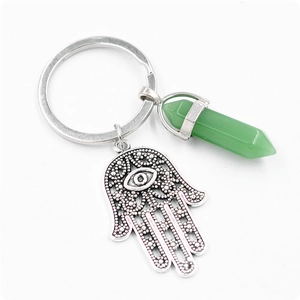 Détail de la main de Fatma argentée et du cristal hexagonal vert sur un porte-clés élégant