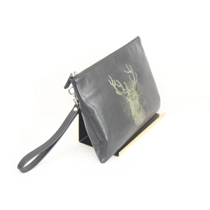 Close-up of black leather clutch with gold deer head print on a metal handbag stand