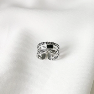 Detailed shot of retro S925 sterling silver ring with black gemstone on white fabric