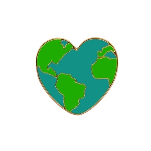 Macro shot of heart-shaped earth enamel pin with gold plating and vibrant green oceans