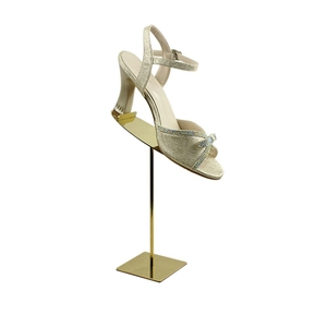 Detail of a champagne gold rhinestone bow sandal on a metallic display stand