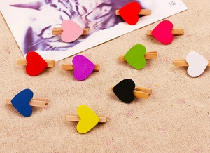 Close-up of colorful wooden heart clips on rustic burlap for creative home decor and photo display