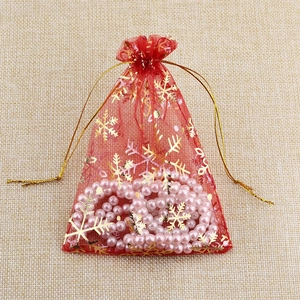 Red organza gift bag with gold snowflake print and drawstring for Christmas jewelry
