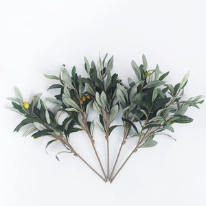 Detail of four artificial olive branches with lifelike green leaves and multicolored fruits