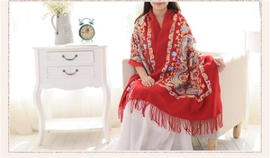 Detail of red wool shawl with ethnic Nepal embroidery and elegant fringe tassels