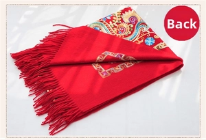 Detailed embroidery on the reverse side of a red ethnic wool scarf with fringe edge