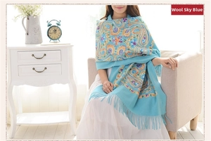 Close-up of sky blue wool shawl featuring intricate ethnic paisley embroidery and tassels