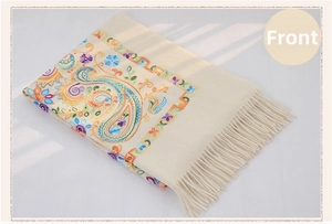 Detailed embroidery on a beige wool shawl featuring colorful paisley floral patterns
