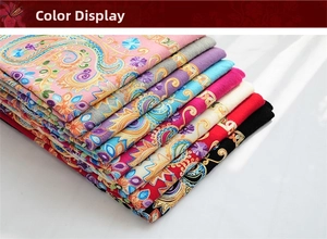Close-up of stacked wool shawls showing colorful Paisley embroidery and floral details