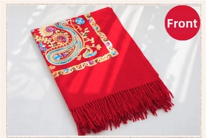 Detail of red wool shawl with intricate paisley floral embroidery and tassel fringe edges