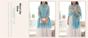 Detailed embroidery on blue wool shawl featuring paisley patterns and elegant tassels