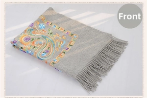 Detail of colorful paisley embroidery and fringe on a grey wool pashmina shawl