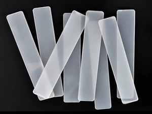 Detail view of 8 translucent rectangular nail art display strips on black background