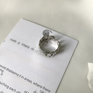 Macro shot of S925 sterling silver chain ring with a single pearl on care card