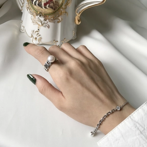 Detail of S925 silver chain ring with pearl and matching zircon bracelet on model hand