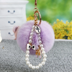 Détail d'un porte-clés en fausse fourrure lavande avec pendentif ballerine et perles