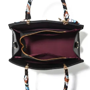 Interior detail of large black leather handbag showing multi-layer storage compartments