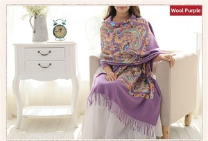 Close-up of purple wool shawl with detailed multicolor paisley embroidery and tassels