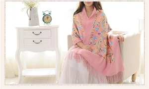 Close-up of pink wool shawl with intricate paisley embroidery and elegant fringe details