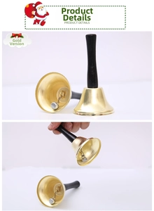 Detail of a golden Christmas hand bell featuring a black long handle and metallic bell body
