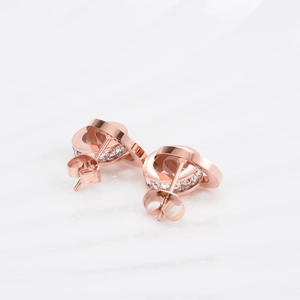Detail of rose gold double ring earrings with clear cubic zirconia pavé and Roman numerals