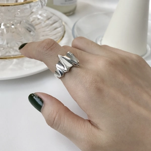 Close-up of geometric zigzag silver ring in a minimalist style worn on index finger