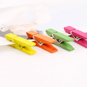 Set of four colorful mini wooden clothes pegs for photo display and home decoration