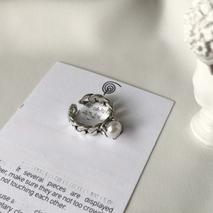 Detail shot of a S925 silver retro chain ring with a large white pearl on a card