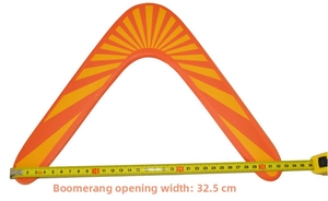 Dettaglio di un boomerang arancione largo 32,5 cm misurato con un metro a nastro giallo