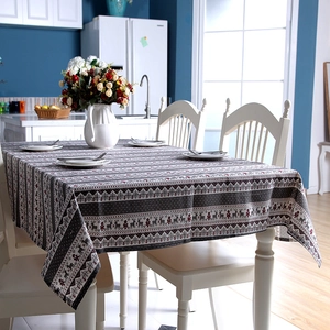 Cozy dining room scene featuring a Christmas tablecloth with reindeer and tree patterns