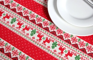 Detailed pattern of reindeer and snowflakes on a festive red Christmas tablecloth