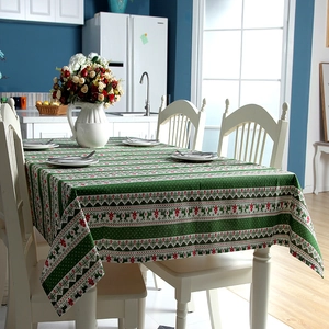 Detailed view of Christmas tablecloth with red reindeer and green tree nordic patterns