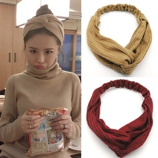 Detail of twisted khaki and burgundy ribbed knit headbands showing texture and fit