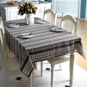 Close-up of Christmas tablecloth featuring red reindeer and tree patterns on grey stripes